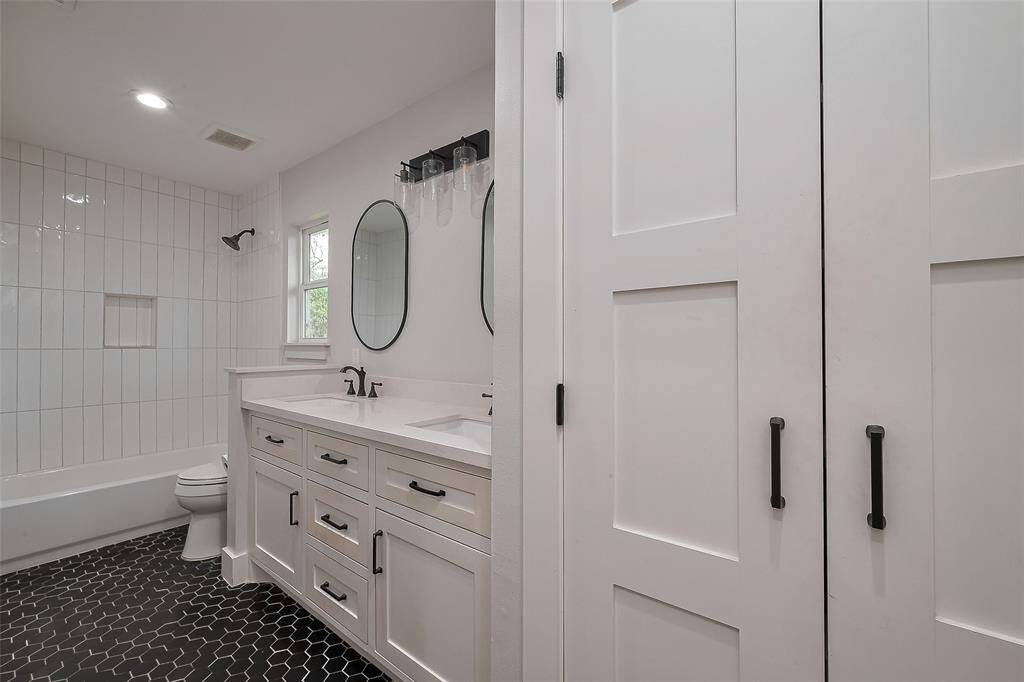 Guest bathroom with double sinks, offering ample space and modern finishes.