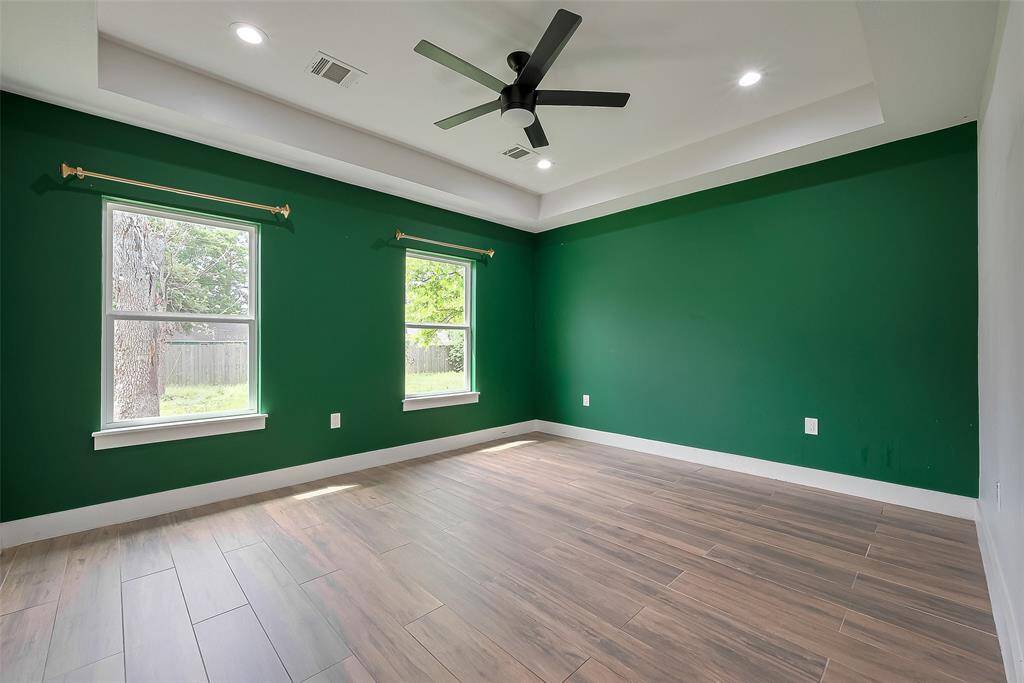 Spacious primary bedroom with abundant natural light and ample room for relaxation.