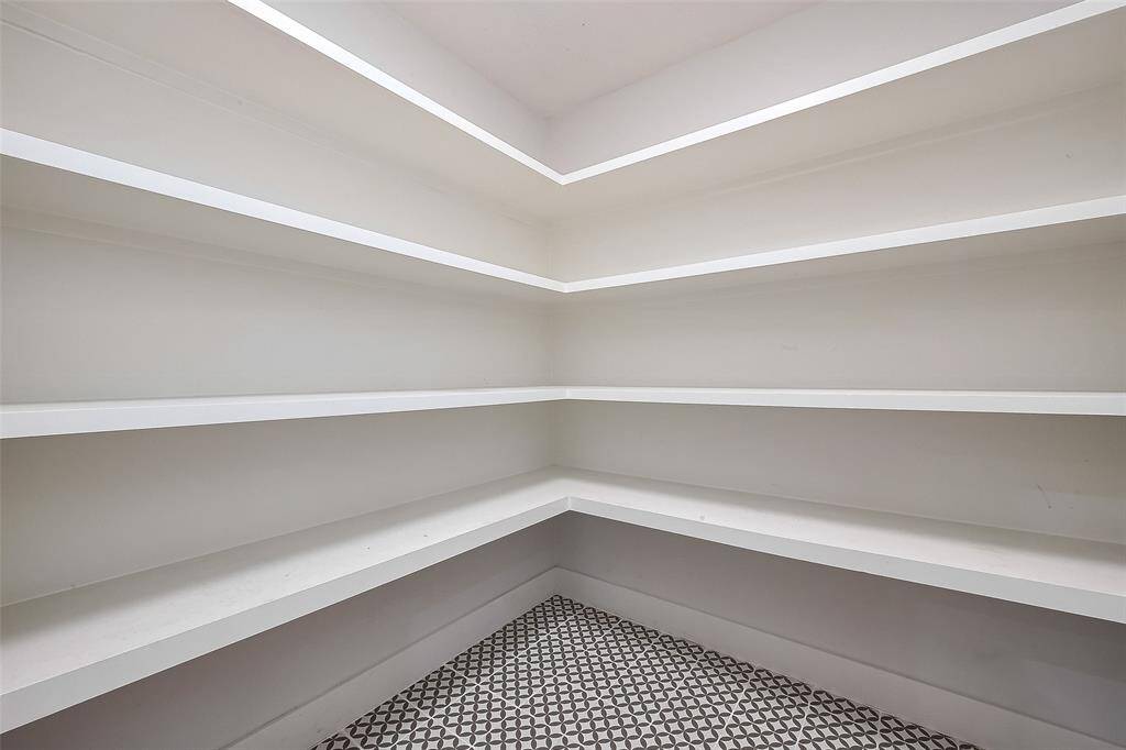 Primary closet featuring built-in shelves for organized storage and easy access