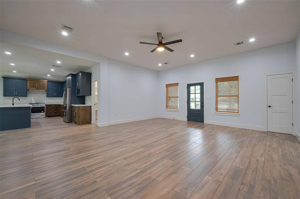 Bright living room opens to kitchen, creating a seamless and airy layout.