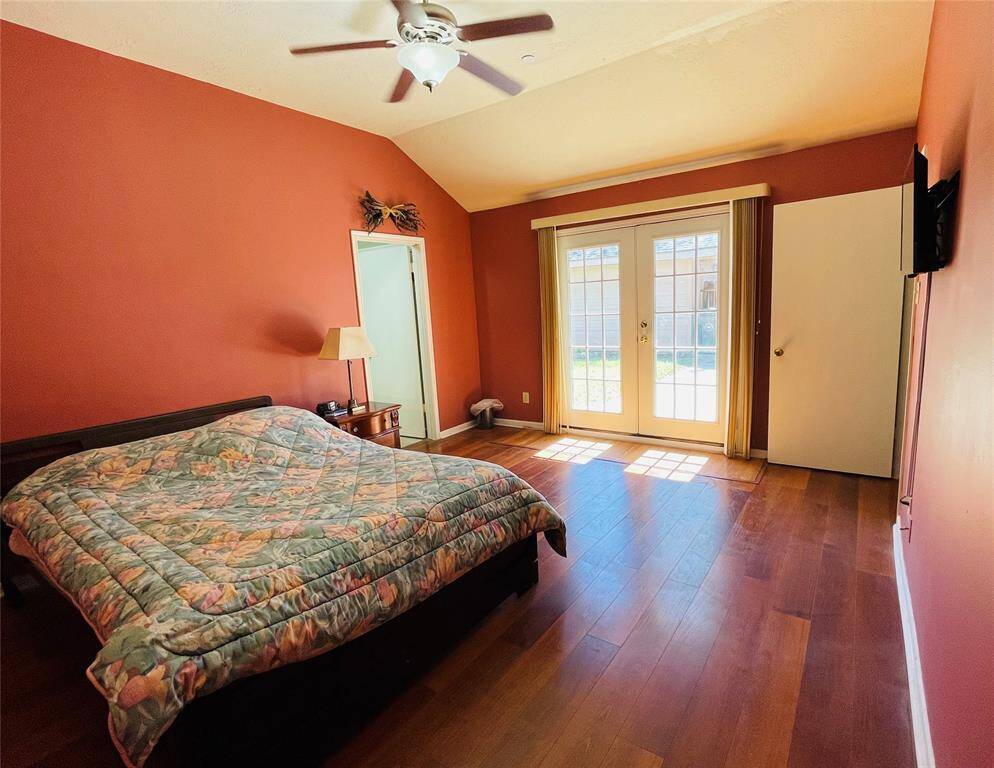 Double doors in primary bedroom lead in/out to concrete patio and fenced backyard.