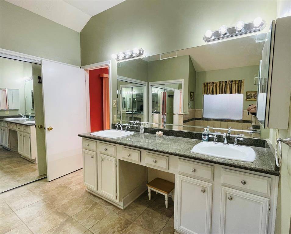 Dual sinks in the primary bathroom. Vanity area is convenient for you.