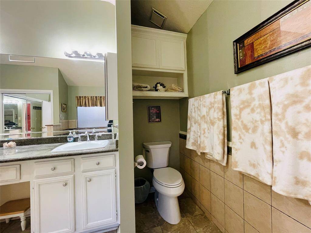 Privacy wall in primary bathroom separates the lavatory area.