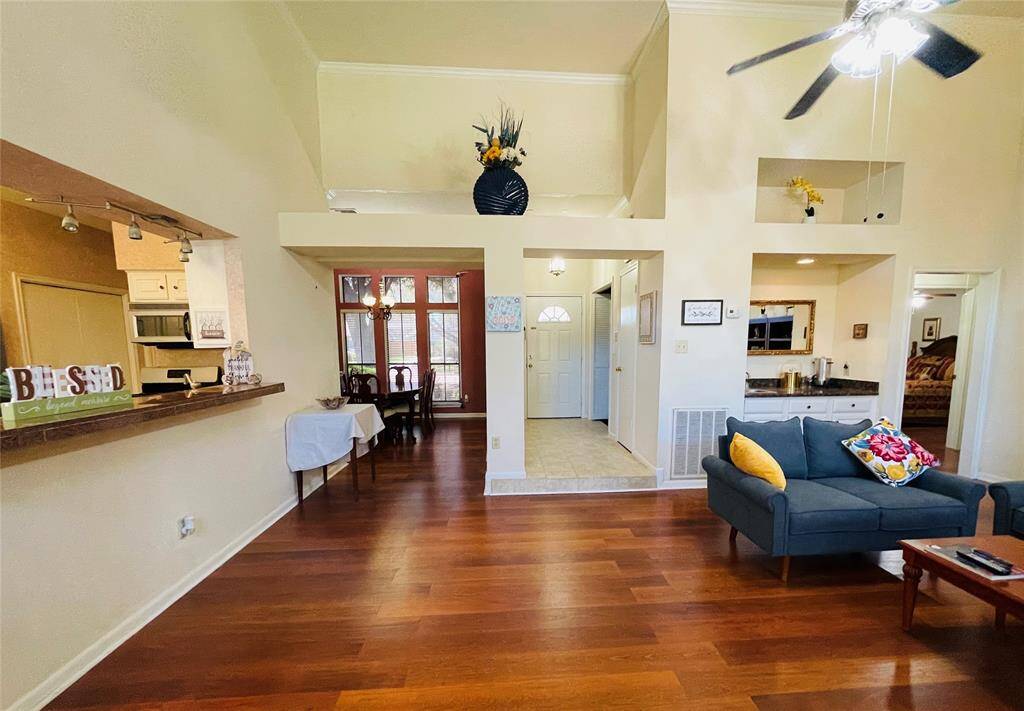View from the den which looks to breakfast bar, dining room, foyer, and wetbar. The wide plank engineered floors are throughout the home except the tiled areas.  Did you notice bedroom 2 to the right in the background?