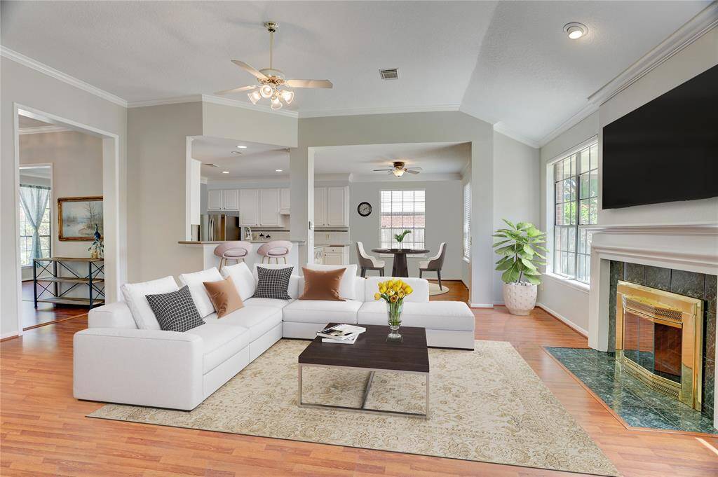 The living room is stunning, with beautiful black pane windows, wood-like laminate flooring, custom tall ceilings and ample space and natural light.