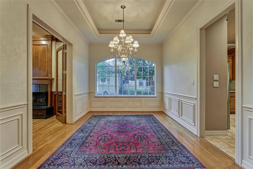 This elegant dining room, just off the foyer, features a stunning chandelier and a sophisticated tray ceiling.