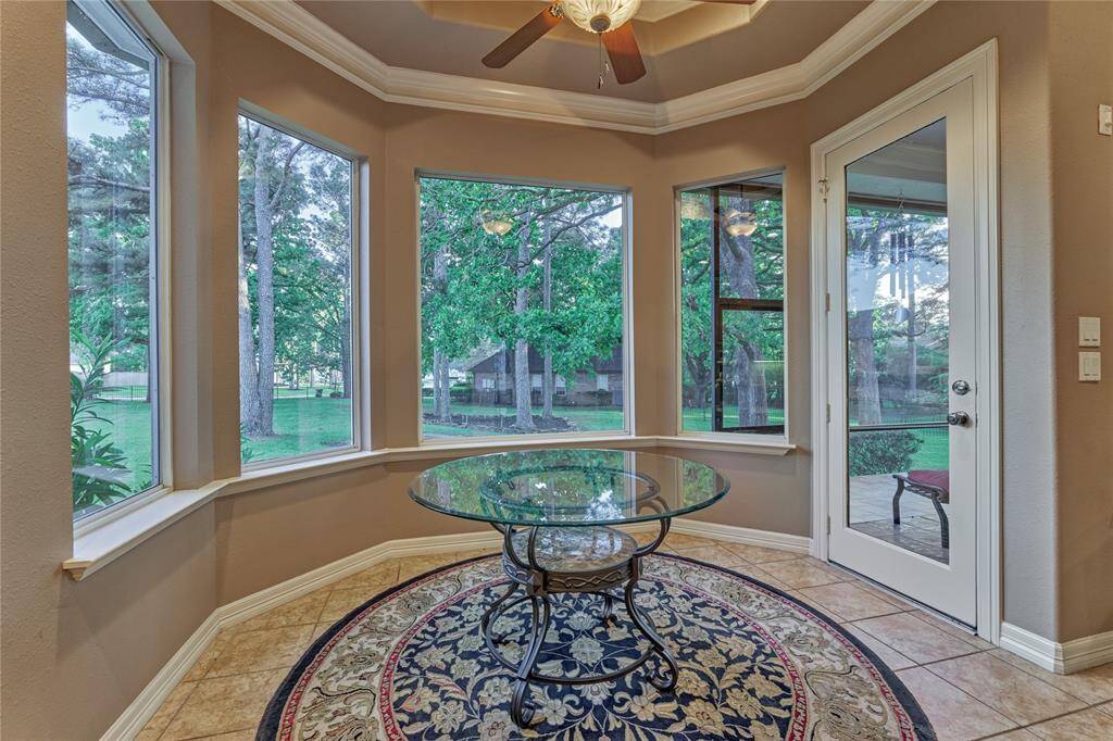 Enjoy panoramic views of the serene backyard through bay windows in the breakfast nook, with a French door leading to the screened porch.
