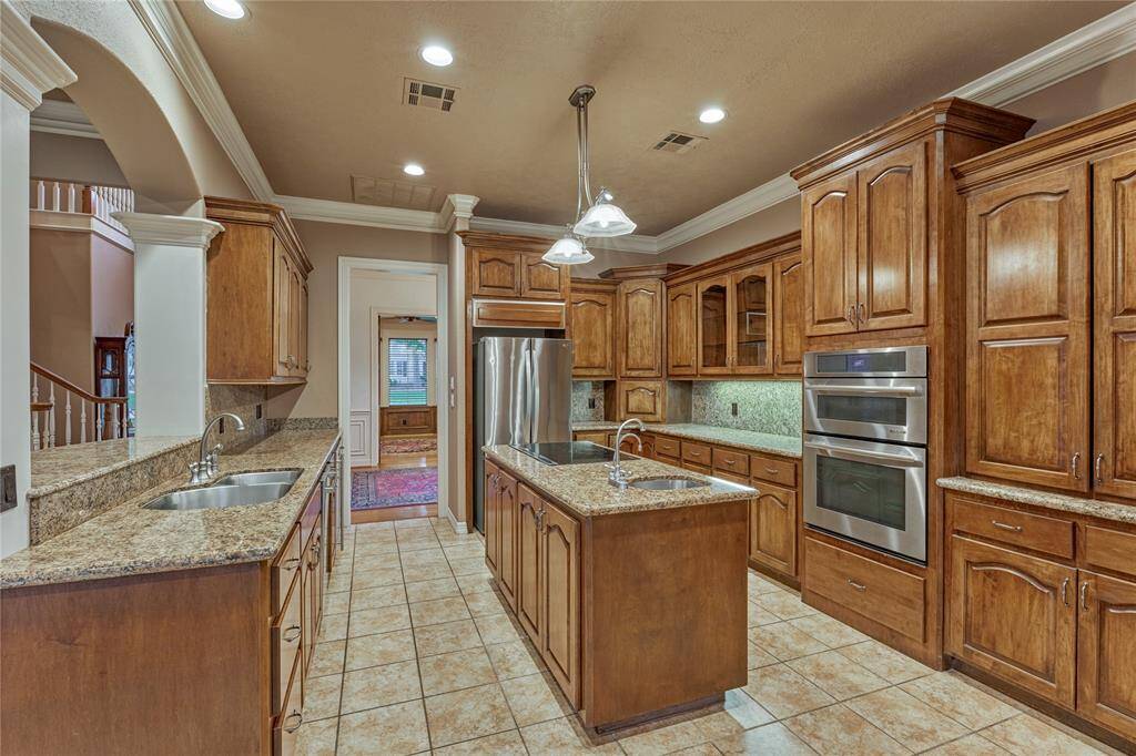 This chef's kitchen features stainless steel appliances and ample rich wood cabinetry for generous storage.