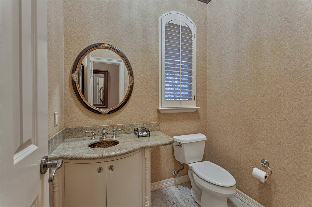 Elegant half-bath featuring stylish plantation shutters.