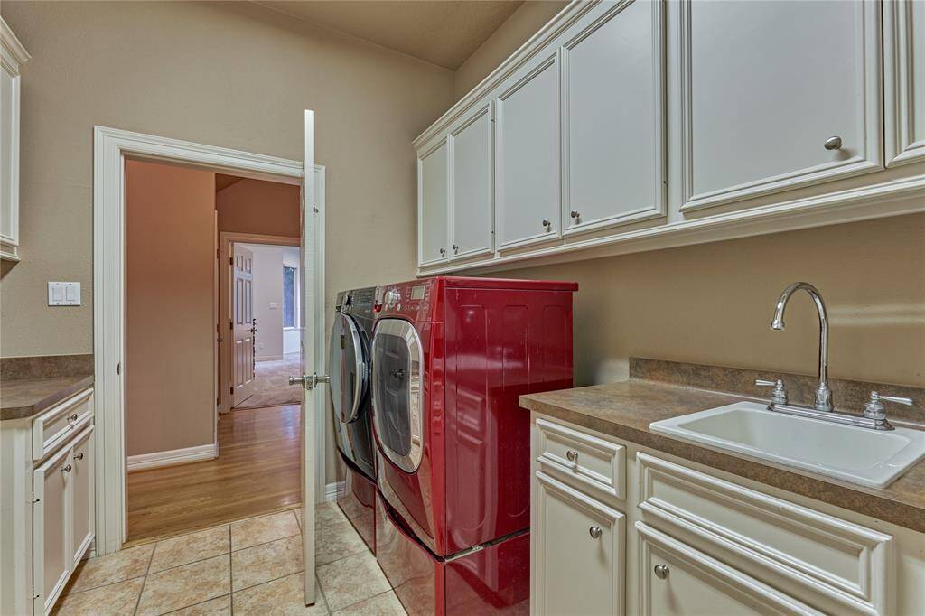 Spacious laundry room with abundant storage and a convenient utility sink.