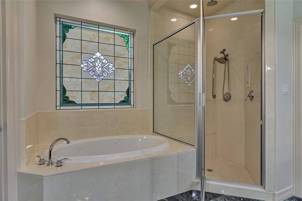 Unwind in this elegant soaker tub, beautifully complemented by a stunning stained-glass window.