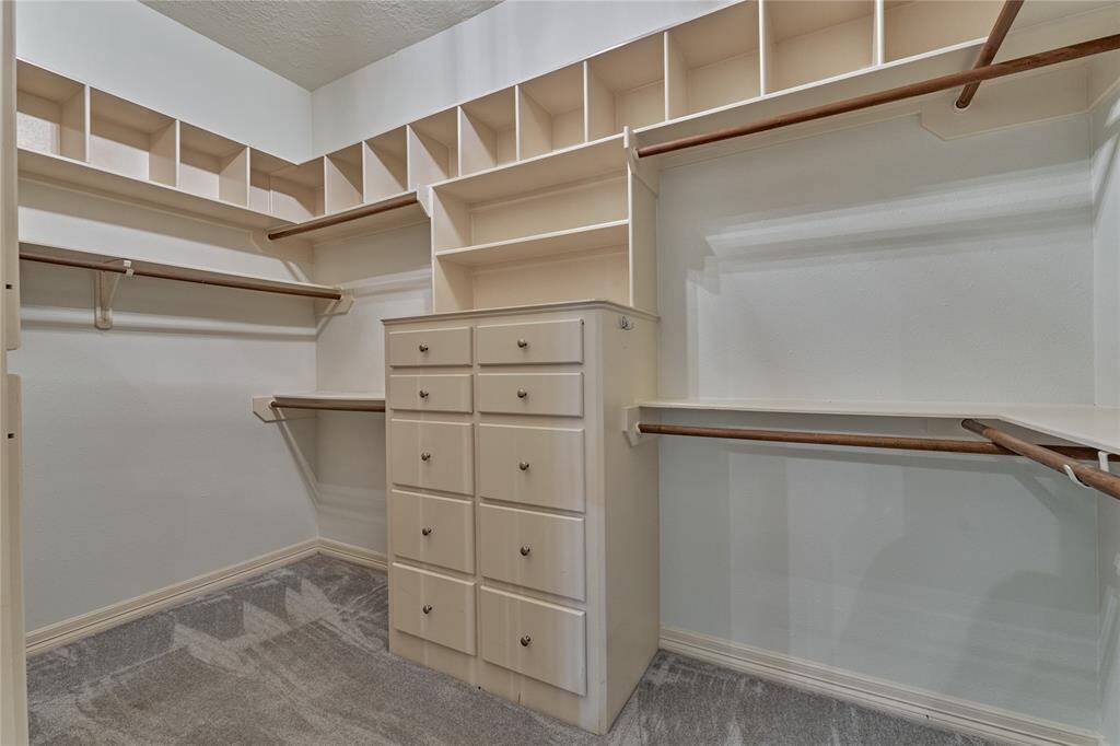Spacious primary closet with exceptional organization and ample storage.
