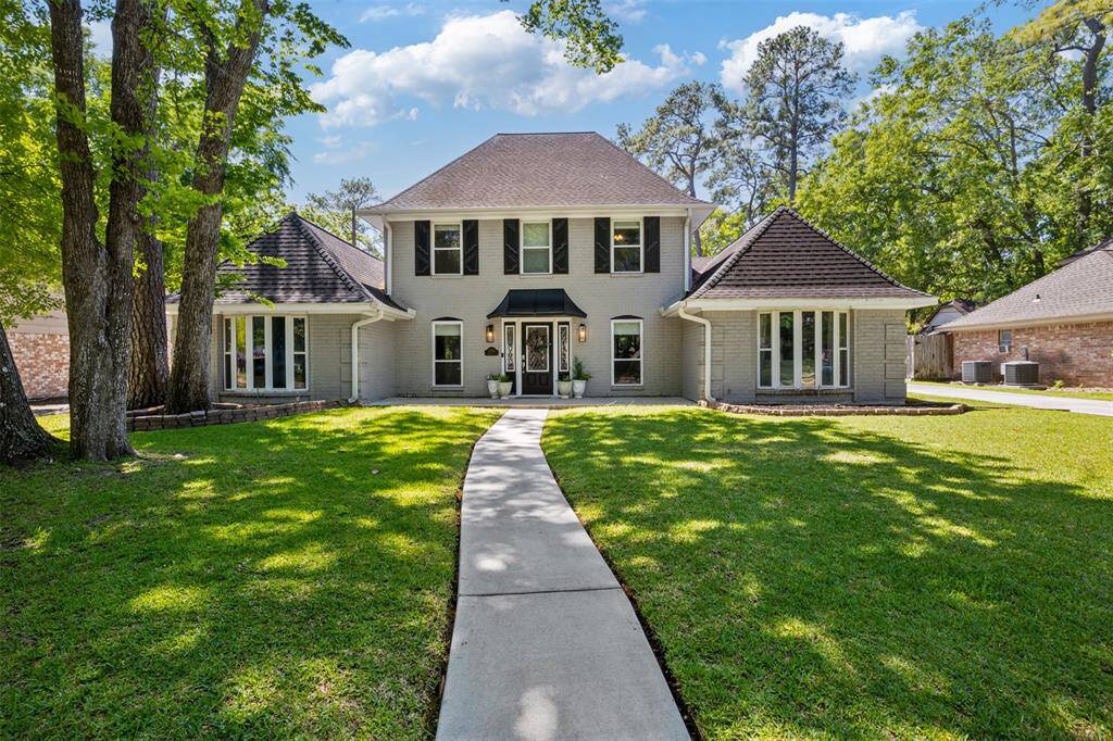 This charming two-story home in the sought after location of Lakewood Forest features a classic brick exterior with a symmetrical design and a welcoming front entrance. It is framed by mature trees and sits on a spacious, well-maintained lawn. The driveway and walkway add to its inviting curb appeal.