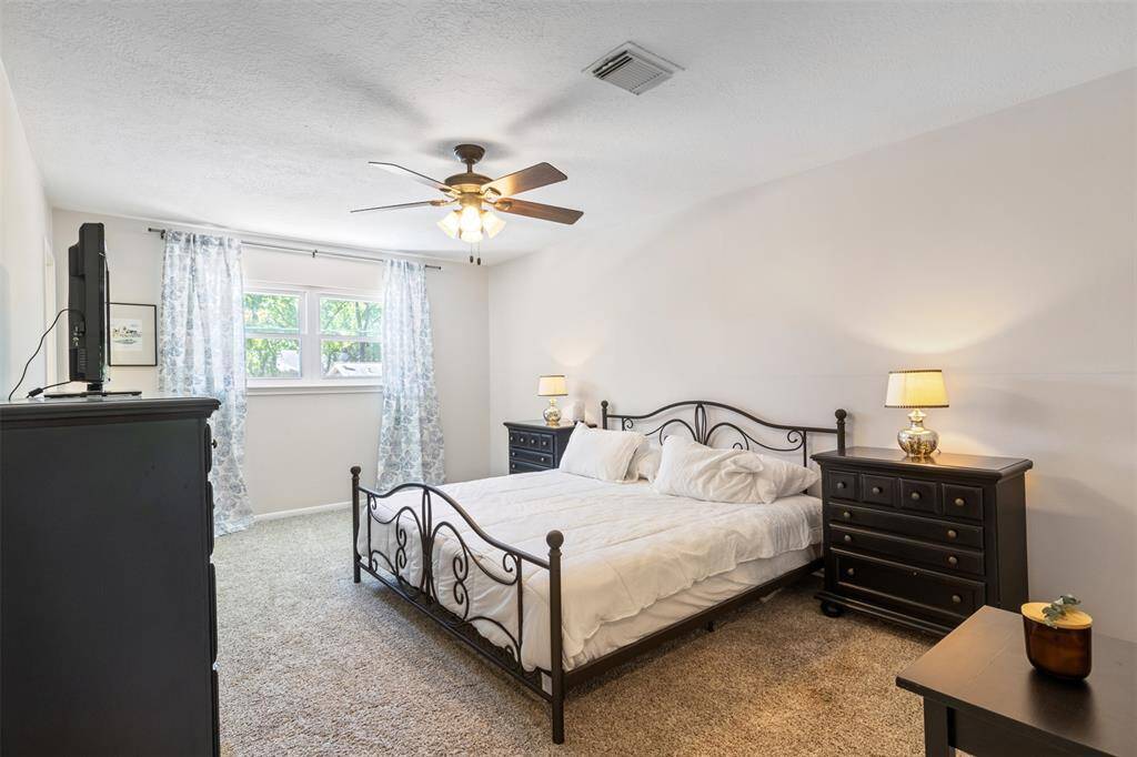 This secondary upstairs bedroom is spacious with a full bathroom attached which could be used as another primary. Natural light streams through the window, creating a bright and inviting atmosphere.