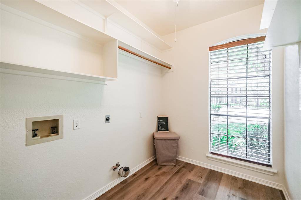 The laundry room, with shelving and hanging space, has room for a full size washer and dryer.