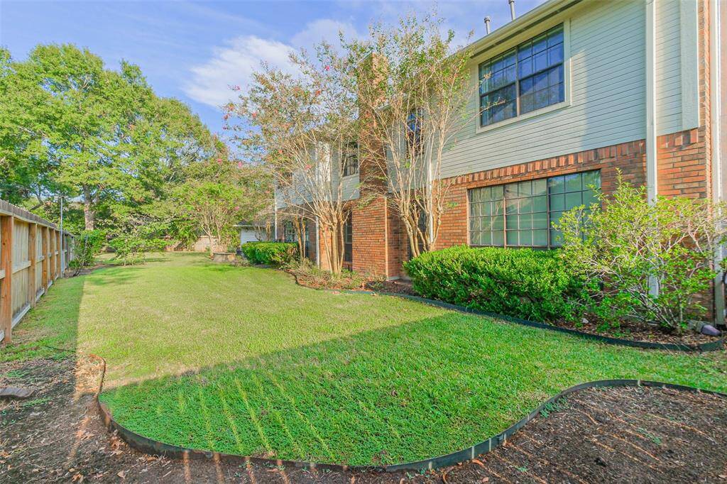 Mature trees and lush landscaping in the backyard.
