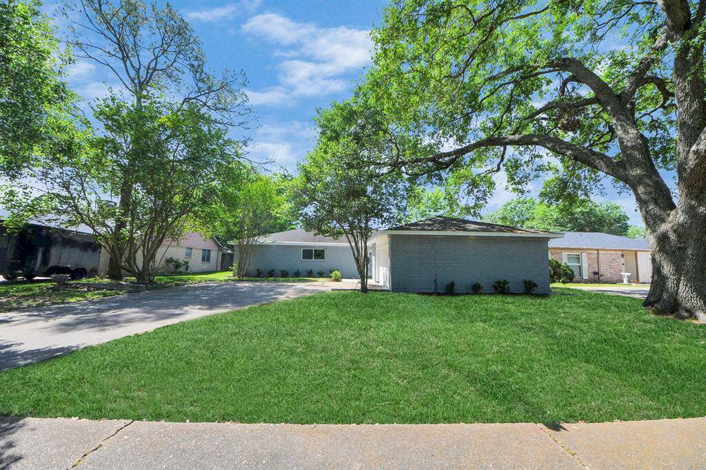 Charming single-story home with a spacious front yard, mature trees, and a long driveway leading to an attached garage. Ideal for those seeking a serene neighborhood setting.