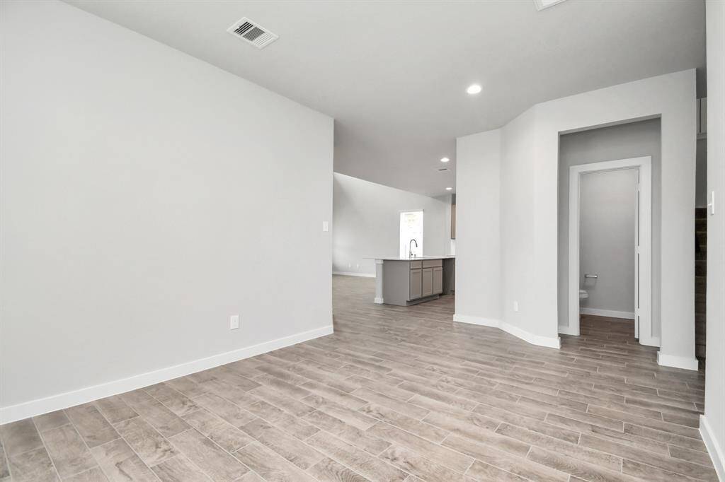Create lasting memories with your family and friends at the dining table in this expansive dining room. It showcases sophisticated flooring, custom paint, and seamlessly connects to the family room and kitchen, providing an open and inviting atmosphere. Sample photo of completed home with similar floor plan. Actual colors and selections may vary.