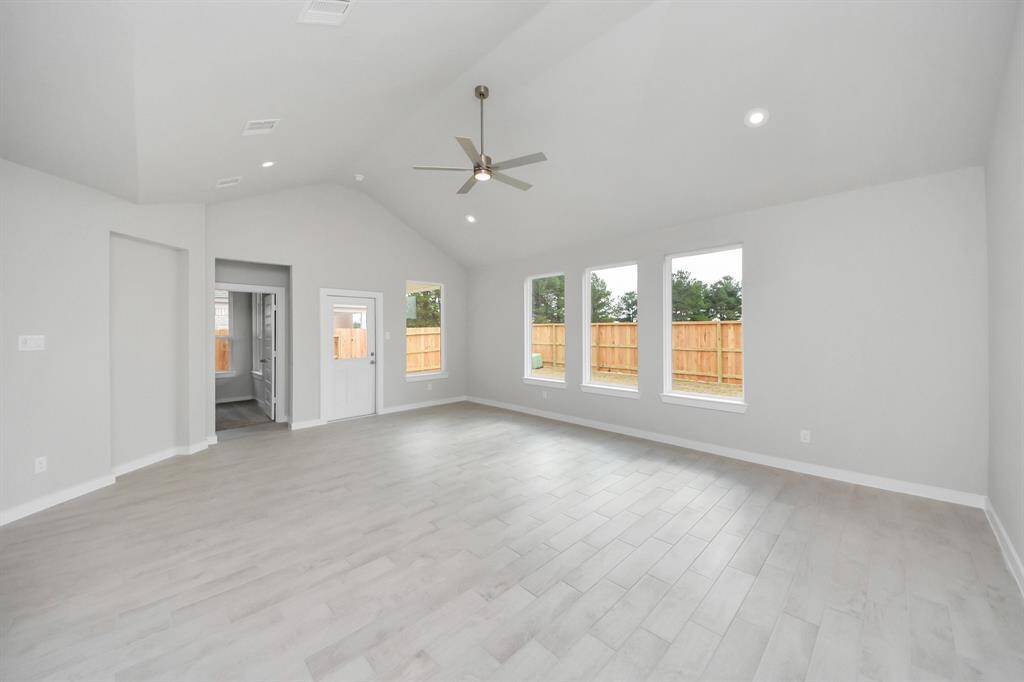 Gather the family and guests together in your lovely living room! Featuring soaring highceilings, recessed lighting, ceiling fan, custom paint, gorgeous floors, and large windows thatprovide plenty of natural lighting throughout the day. Sample photo of completed home with similar floor plan. Actual colors and selections may vary.