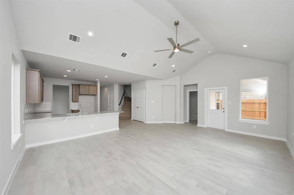 Welcome family and guests to your charming living room! With its high ceilings,recessed lighting, ceiling fan, custom paint, beautiful flooring, and large windows that letin abundant natural light, this room is perfect for gatherings. Sample photo of completed home with similar floor plan. Actual colors and selections may vary.