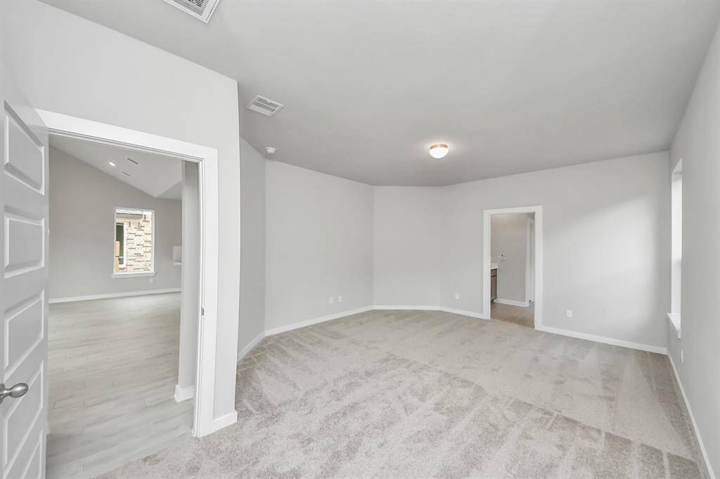 Escape and relax in the exquisite primary suite, a haven to unwind after a long day. Thespacious room, located on first floor, boasts plush carpeting, soothing paint tones, highceilings, and expansive windows adorned with privacy blinds. Sample photo of completed home with similar floor plan. Actual colors and selections may vary.