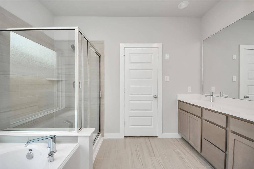 Elevate your dailyroutine at the elegant vanity, now equipped with double sinks, lightcountertops, modern hardware, and beautiful recessed lights. Sample photo of completed home with similar floor plan. Actual colors and selections may vary.