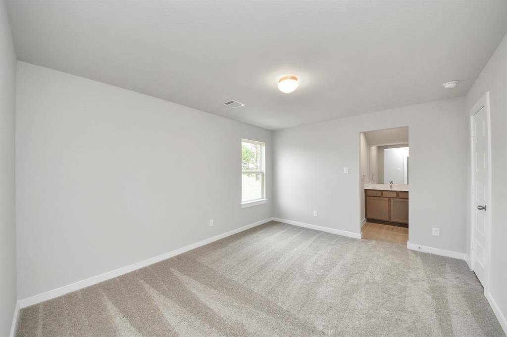 Secondary bedroom features plush carpet, custom paint, large window with privacy blindsand access to the Jack and Jill bath. Sample photo of completed home with similar floor plan. Actual colors and selections may vary.