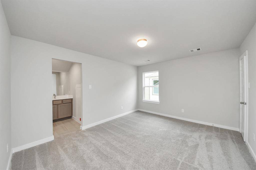 Secondary bedroom features plush carpet, custom paint, large window with privacy blindsand access to the Jack and Jill bath. Sample photo of completed home with similar floor plan. Actual colors and selections may vary.