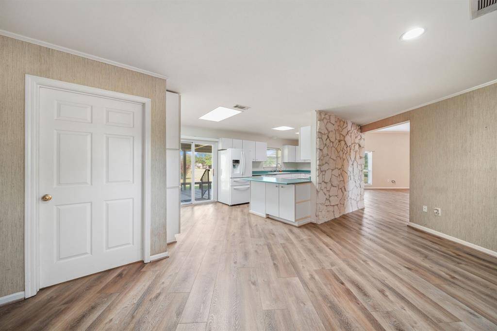 Kitchen with sliding glass door to your serene  Quiet backyard and covered huge back porch made of metal beams.  Home is made to last!  Behind the door is your Laundry Room with 1/2 bath