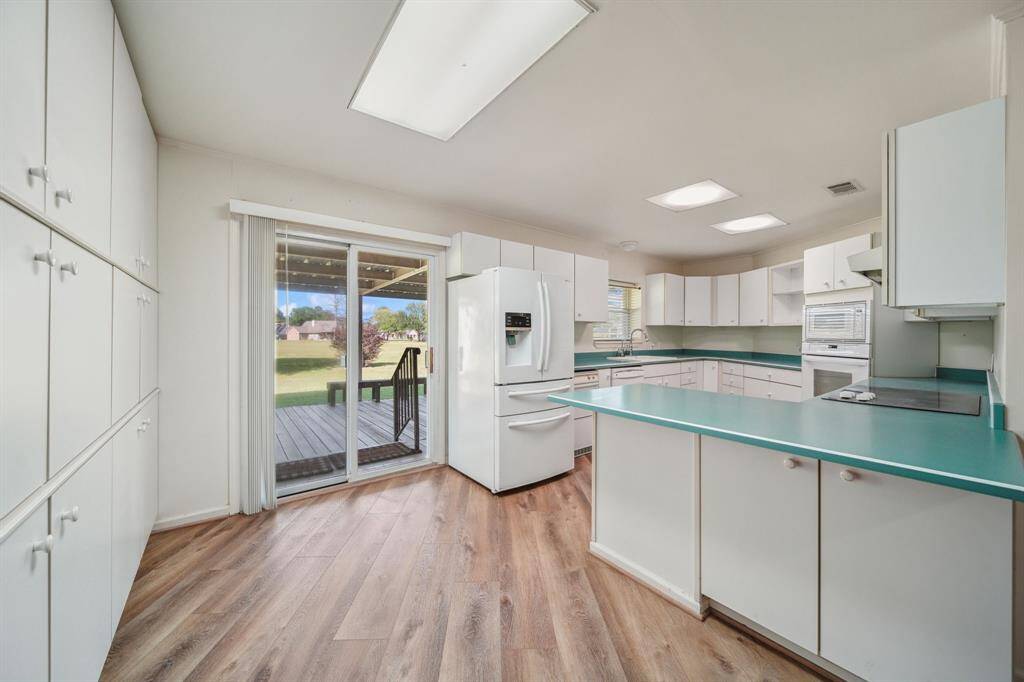 The left wall is all storage cabinets, note the beams in porch ceiling, wrap around seating, breakfast bar, seperateoven and cooktop, kitchen window over looking your backyard