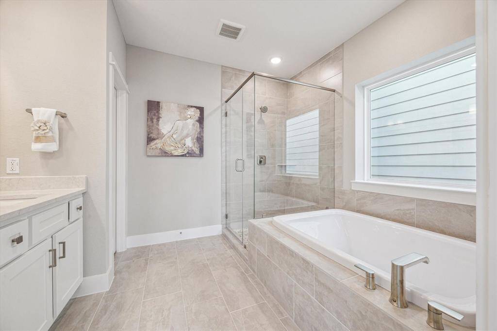 The serene soaking tub and separate shower include tile to the ceiling and tub skirt.