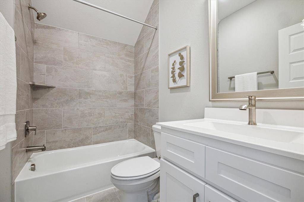 The third floor full bathroom also includes upgraded tile to the ceiling at the bath tub and vanity storage