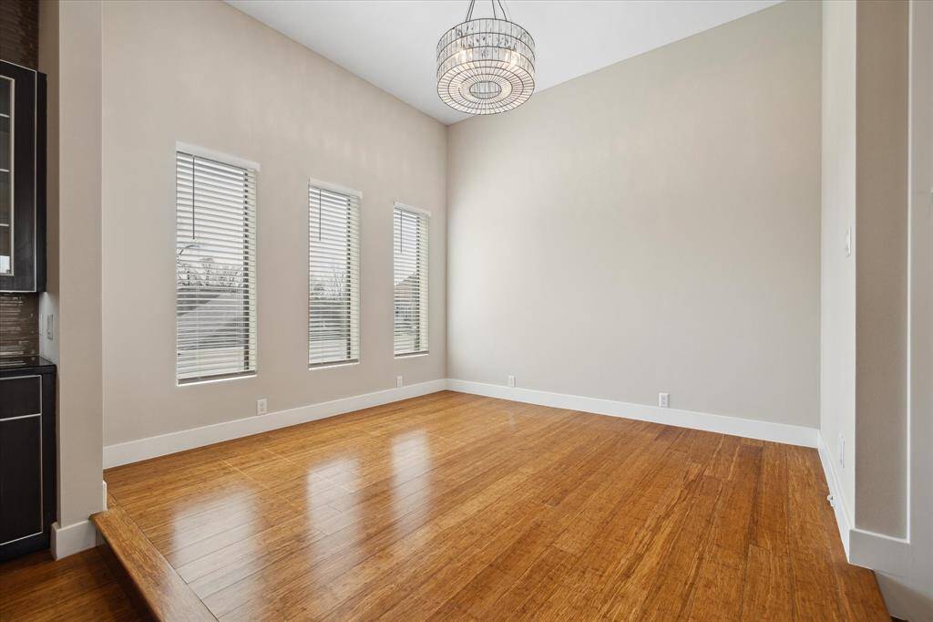 Elevated dining area featuring large windows which fills the space with natural light and a beautiful chandelier.