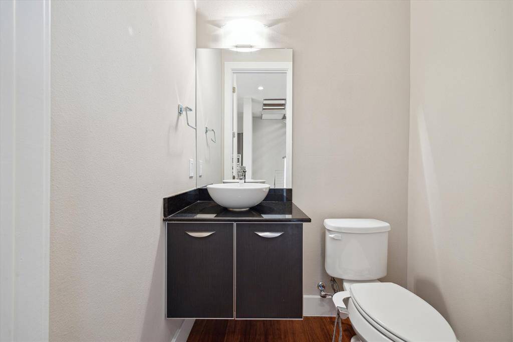 Half bath on the second floor features white vessel sink.