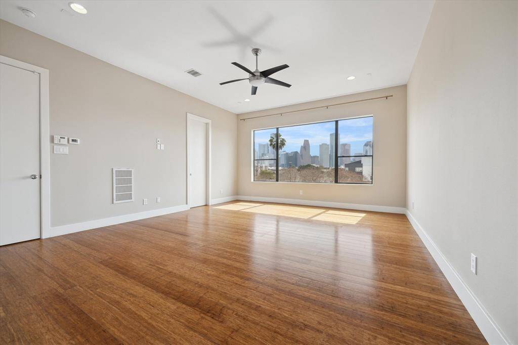 Spacious primary bedroom with stunning panoramic views of Downtown Houston!