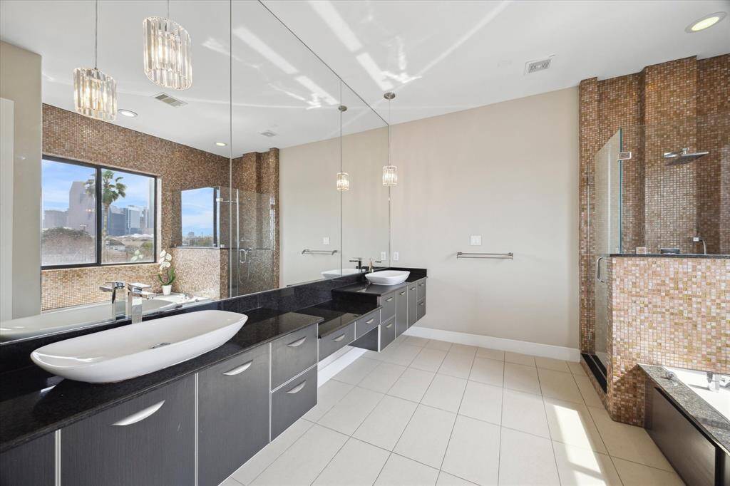 Light and bright bathroom features dual sinks, vanity, and chandelier!