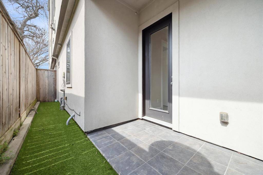 Private outdoor space featuring slate tile flooring and low-maintenance artificial turf.