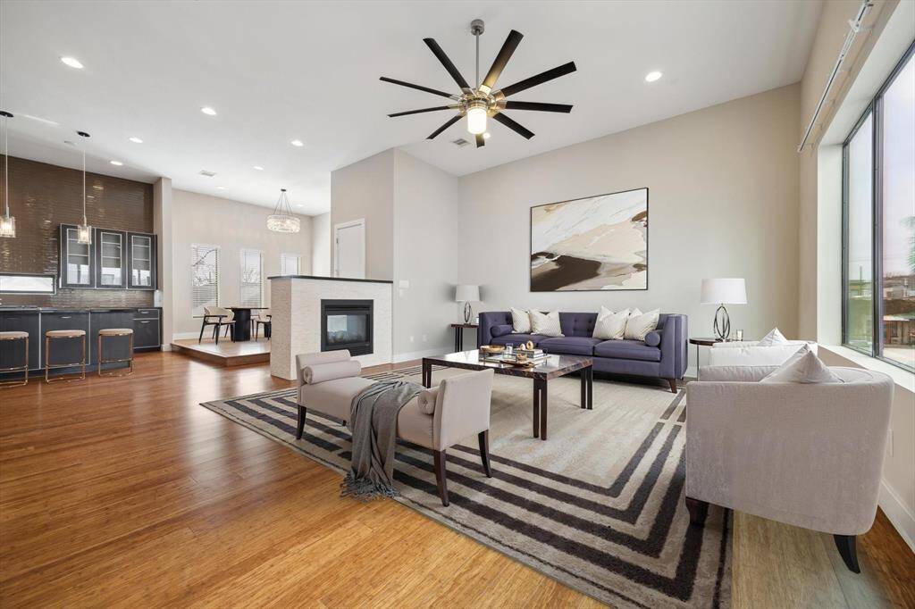 Experience open-concept living at its finest! Spacious family room featuring beautiful wood floors, high ceilings, and a double-sided fireplace – perfect for relaxing or entertaining.