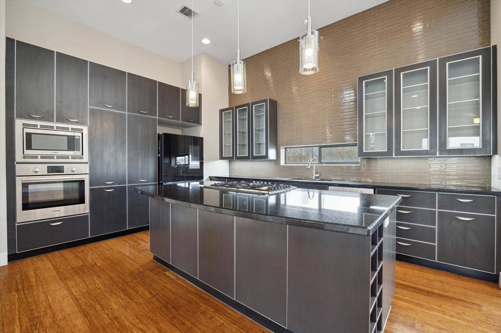 Dream kitchen with Bosch appliances, Samsung smart refrigerator, glass front cabinets, wine refrigerator, soft close drawers, breakfast bar, extensive tile work, and plenty of storage!