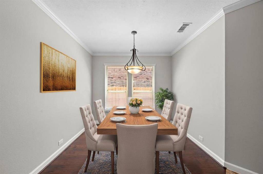 Formal dining room with beautiful hardwoods! Virtually staged.