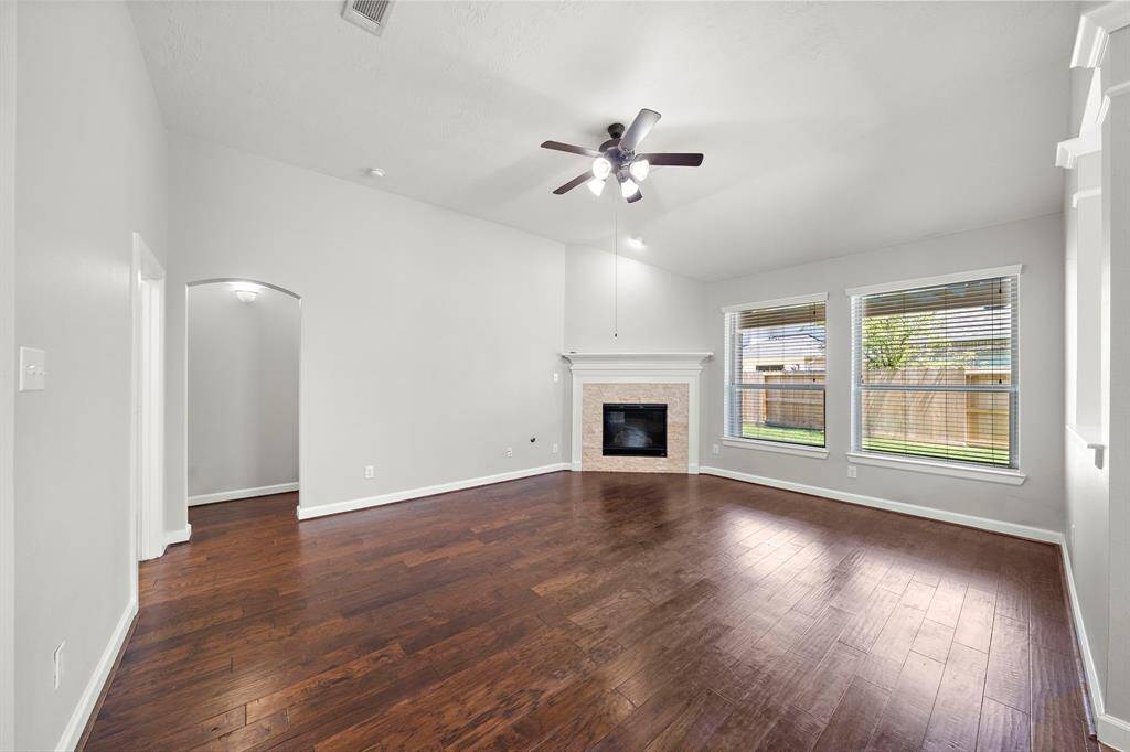 Family room with so much natural light, a gas log fireplace and warm hardwoods opens to the kitchen and breakfast area.