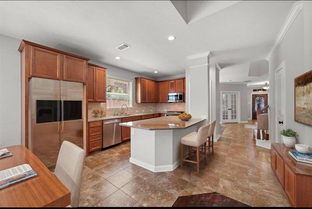 Kitchen open to breakfast area and family room, virtually staged.