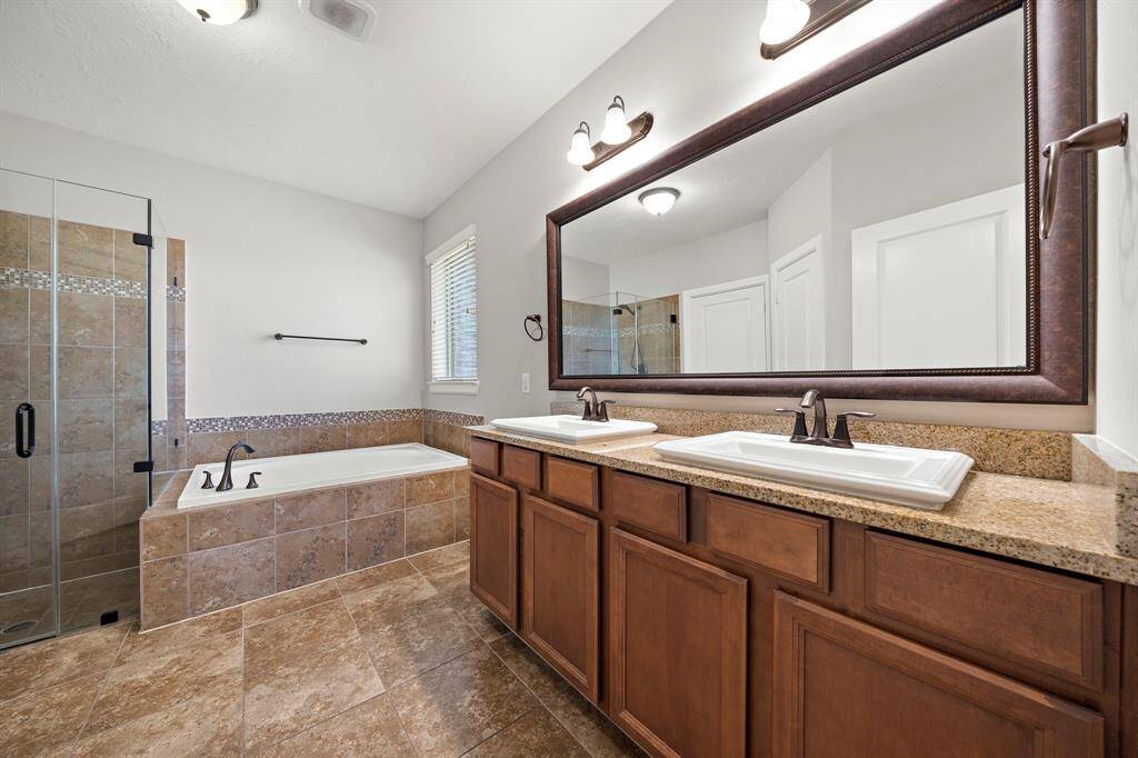 Frameless shower, large soaking tub and his and hers sinks in the primary bathroom. Enjoy endless hot water with new tankless water heater 2023 and water softener 2022.