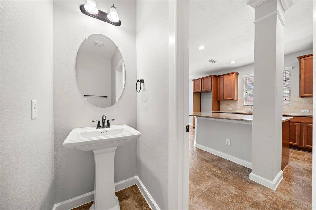 Adorable half bath in hallway before kitchen.