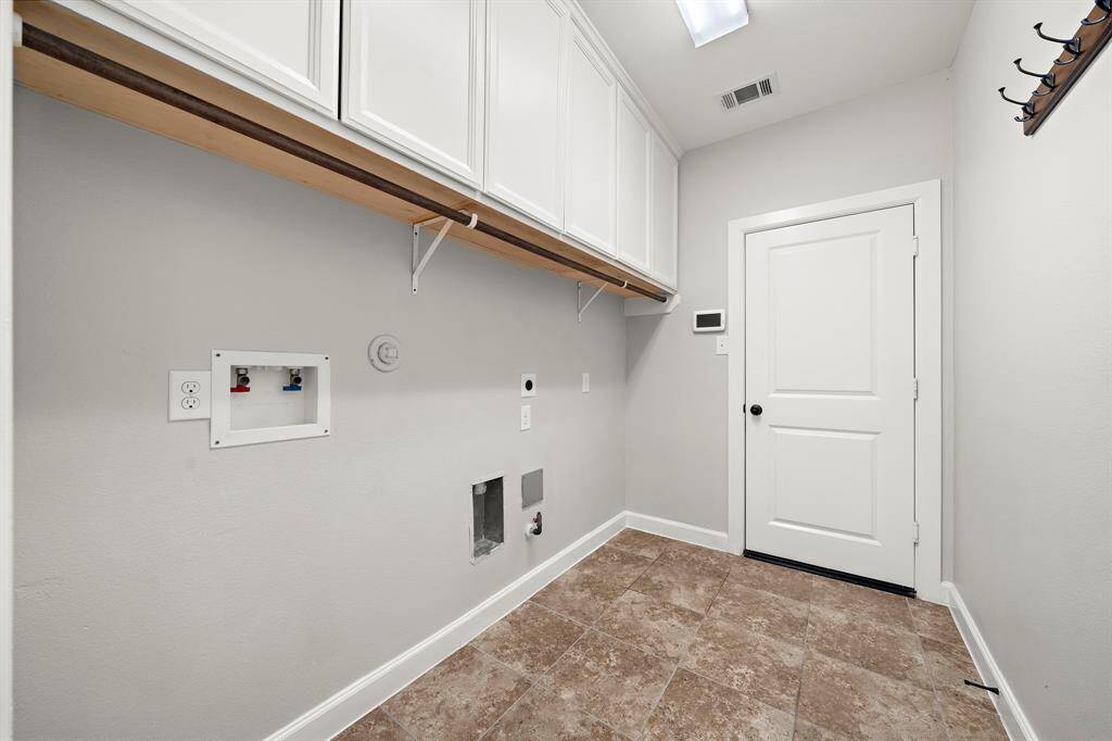 Large laundry room with storage cabinets leads to your 3 car garage