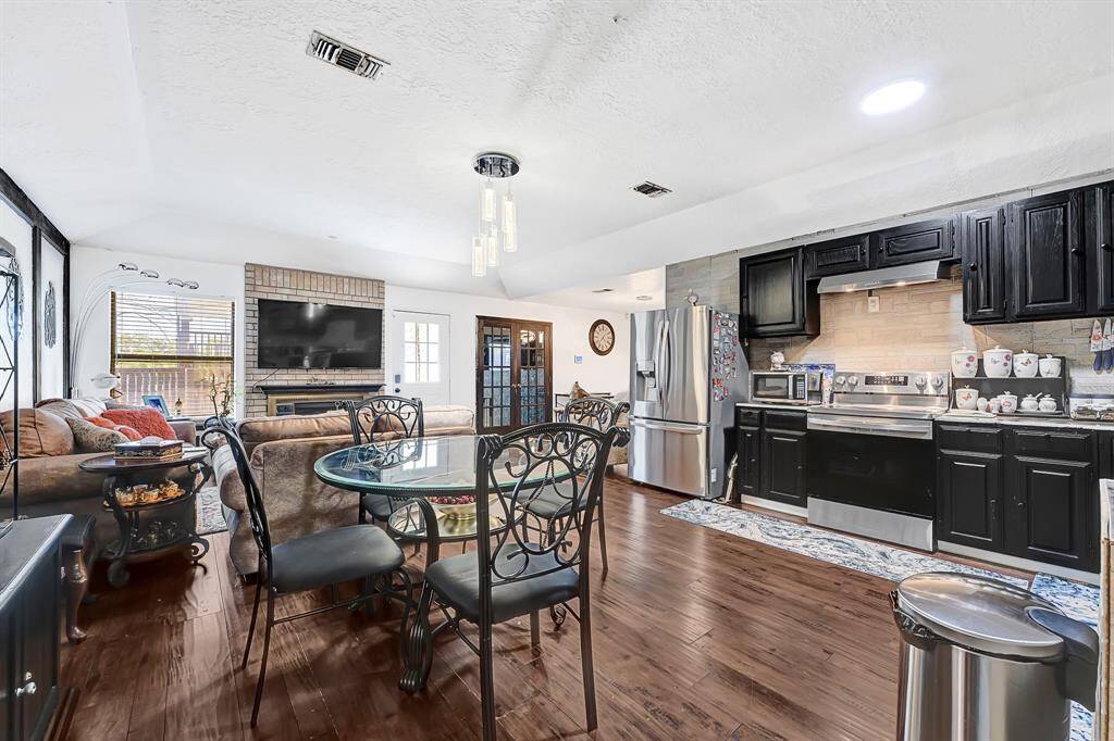 Bright and inviting open-concept layout featuring a charming brick chimney and an abundance of natural light—perfect for cozy living and effortless entertaining.