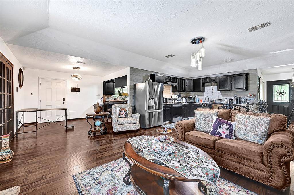 This home features a versatile guest quarters with a private entry. A removed dividing wall now seamlessly showcases the full home, offering an open and connected living space with added flexibility.