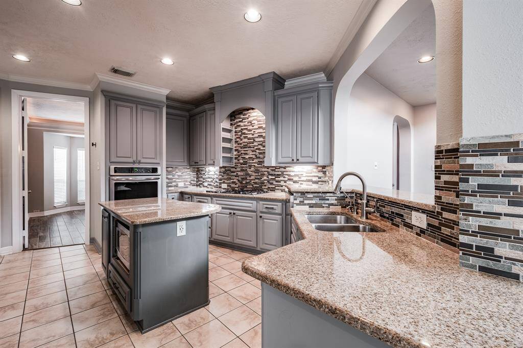 Discover the heart of your new home with this elegantly appointed kitchen, boasting a central island, sophisticated under-cabinet lighting, custom cabinetry, stunning granite countertops, and a spacious walk-in pantry.