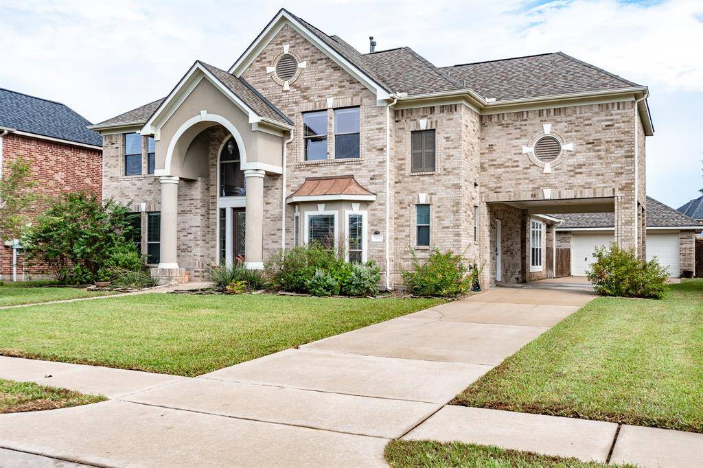 Discover elegance with this home's charming porte-cochère, spacious detached garage, and expansive driveway.