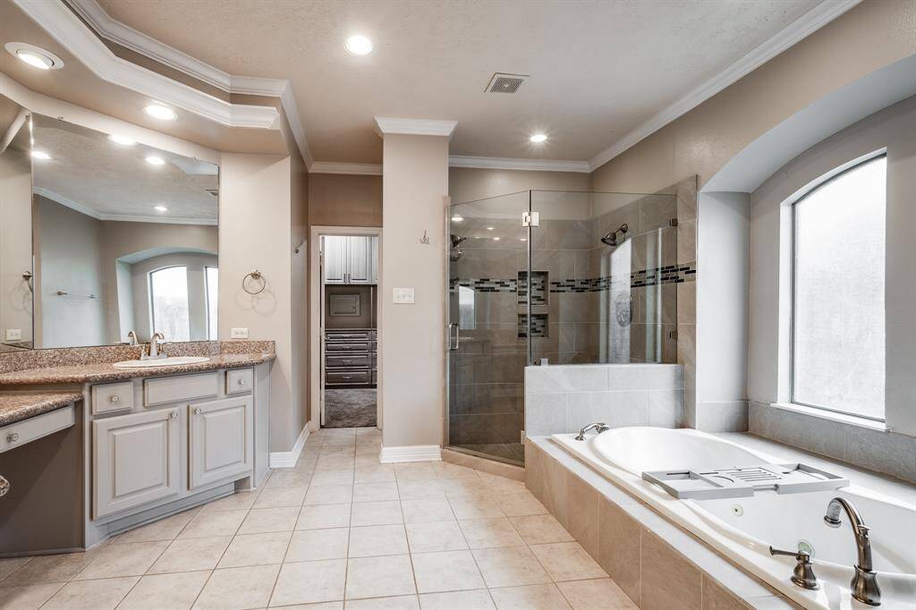 Indulge in serenity in the luxurious en suite, featuring a spacious soaking tub, a sleek walk-in shower, a double vanity, and a  walk-in closet.